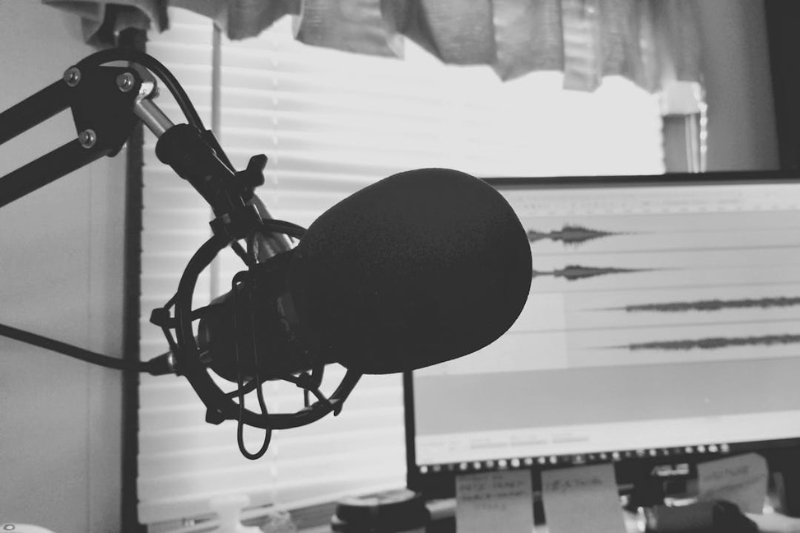 Grayscale photo of a microphone and a computer